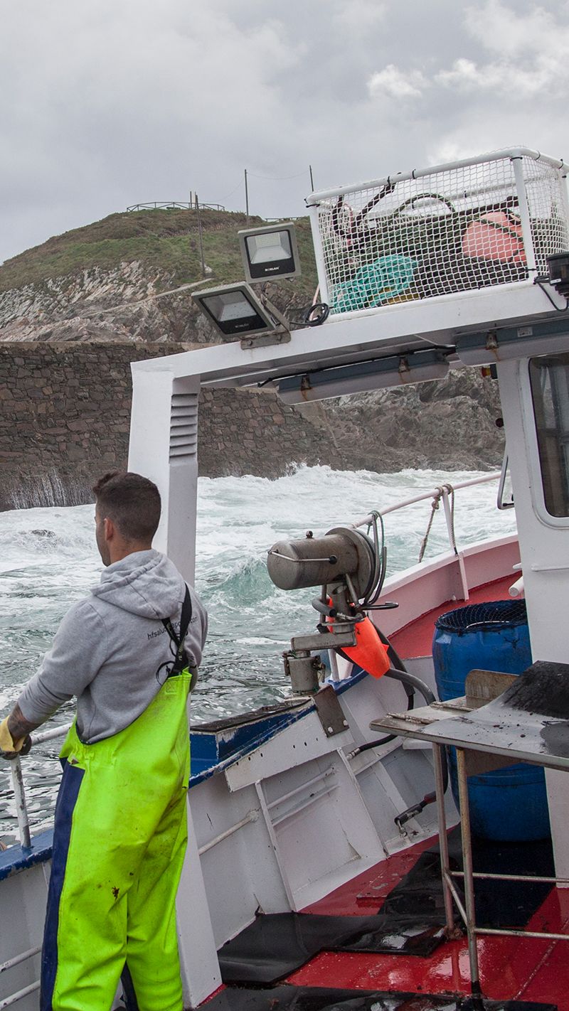 Man in overalls on small boat on rough sea